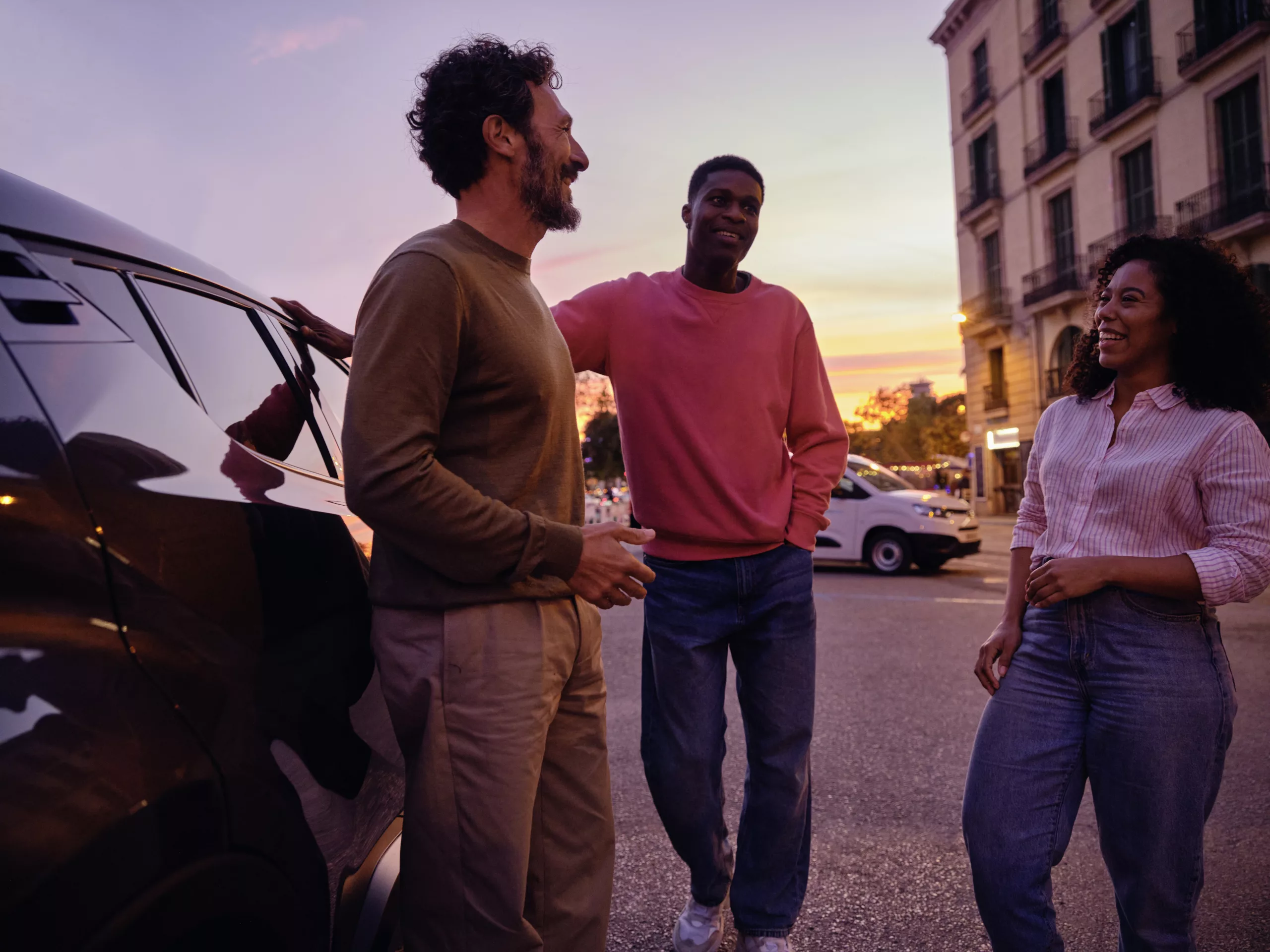 groep vrienden zonsondergang naast zwarte auto